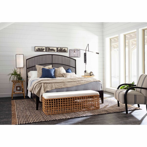 wicker bench at the foot of a bed in a coastal styled room